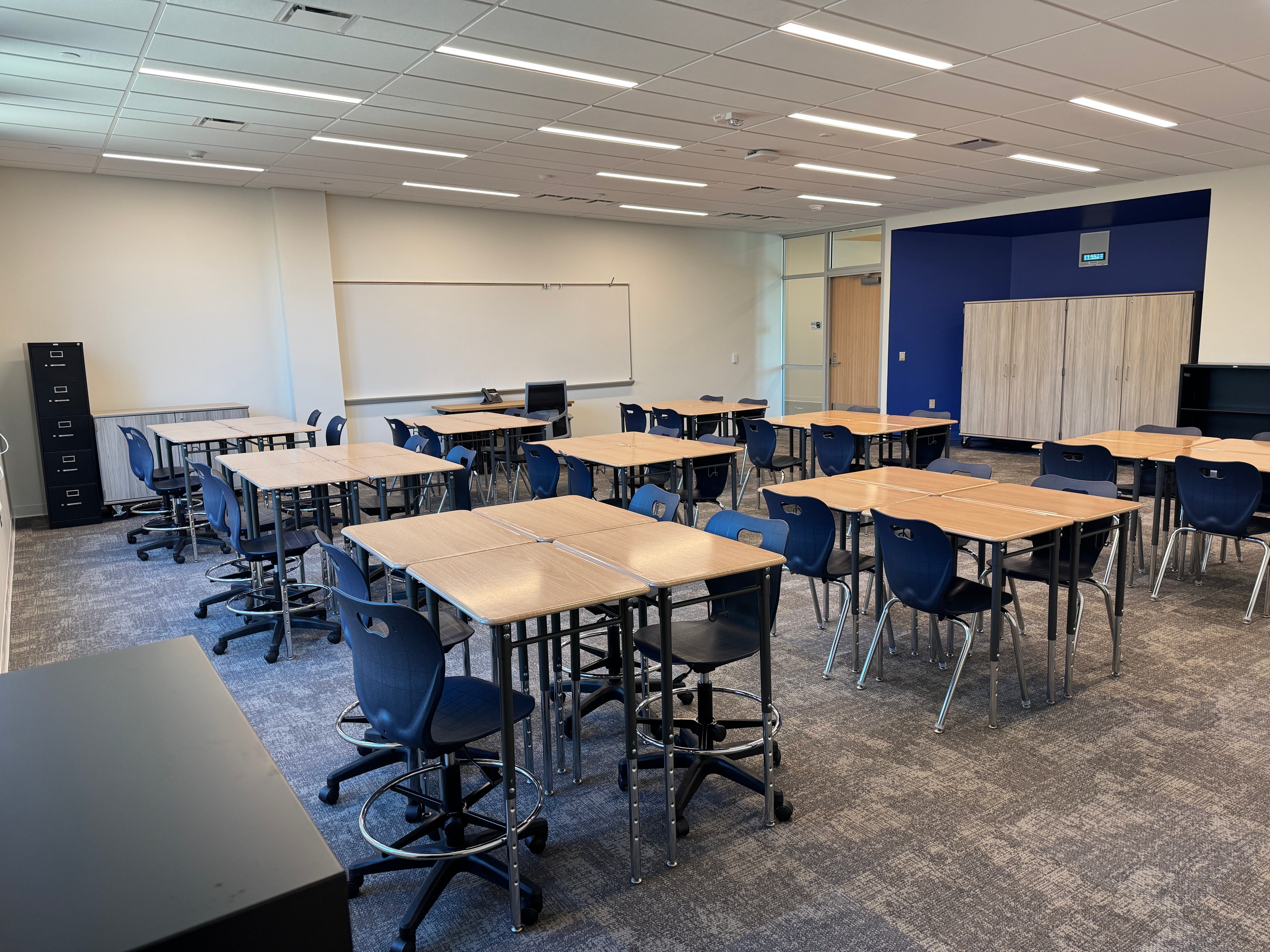 Completed classroom setup with navy blue chairs and wood tables