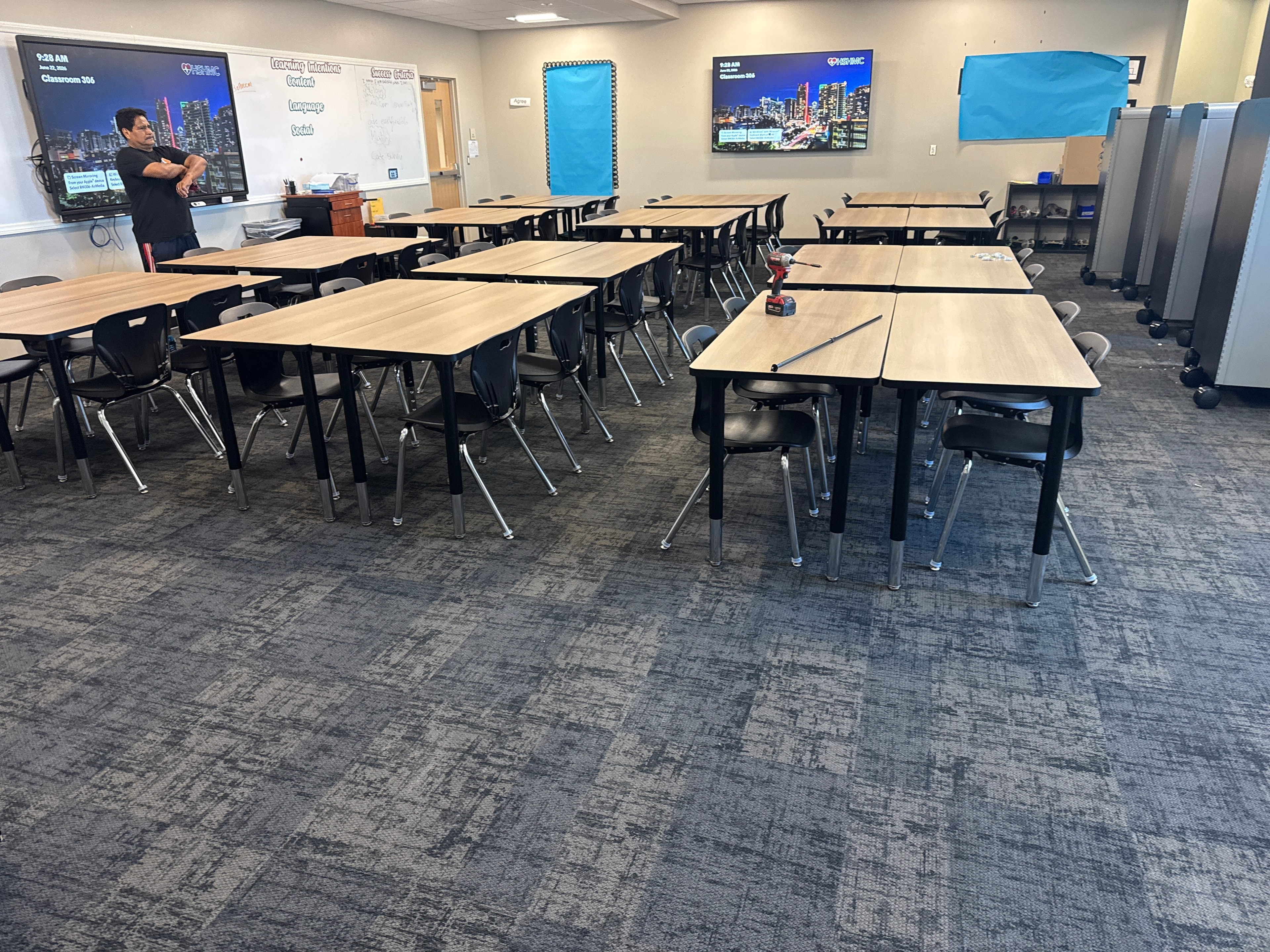 Classroom furniture installation in progress — wood-top desks and chairs