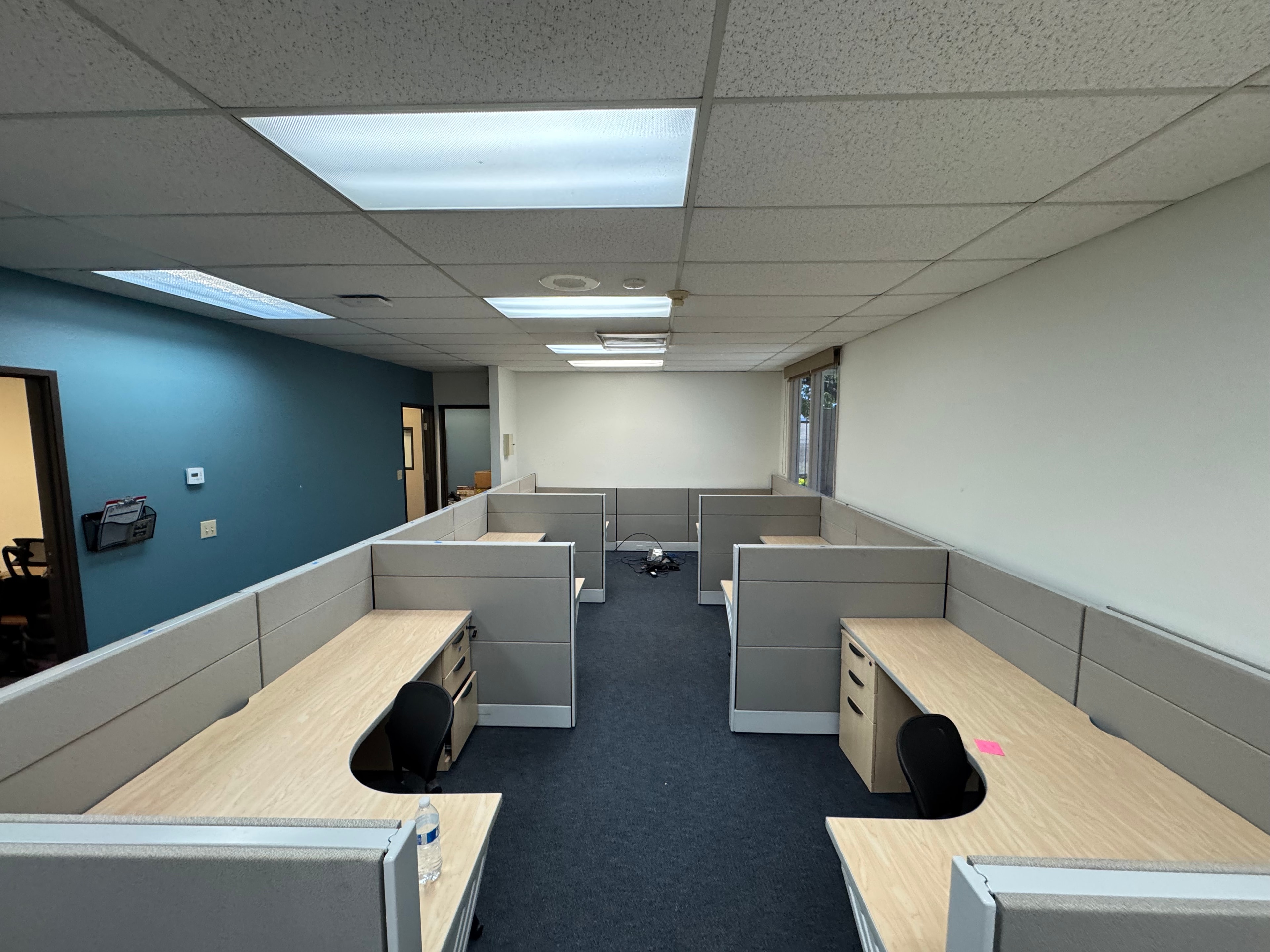 Office cubicle workstation installation with blue accent wall