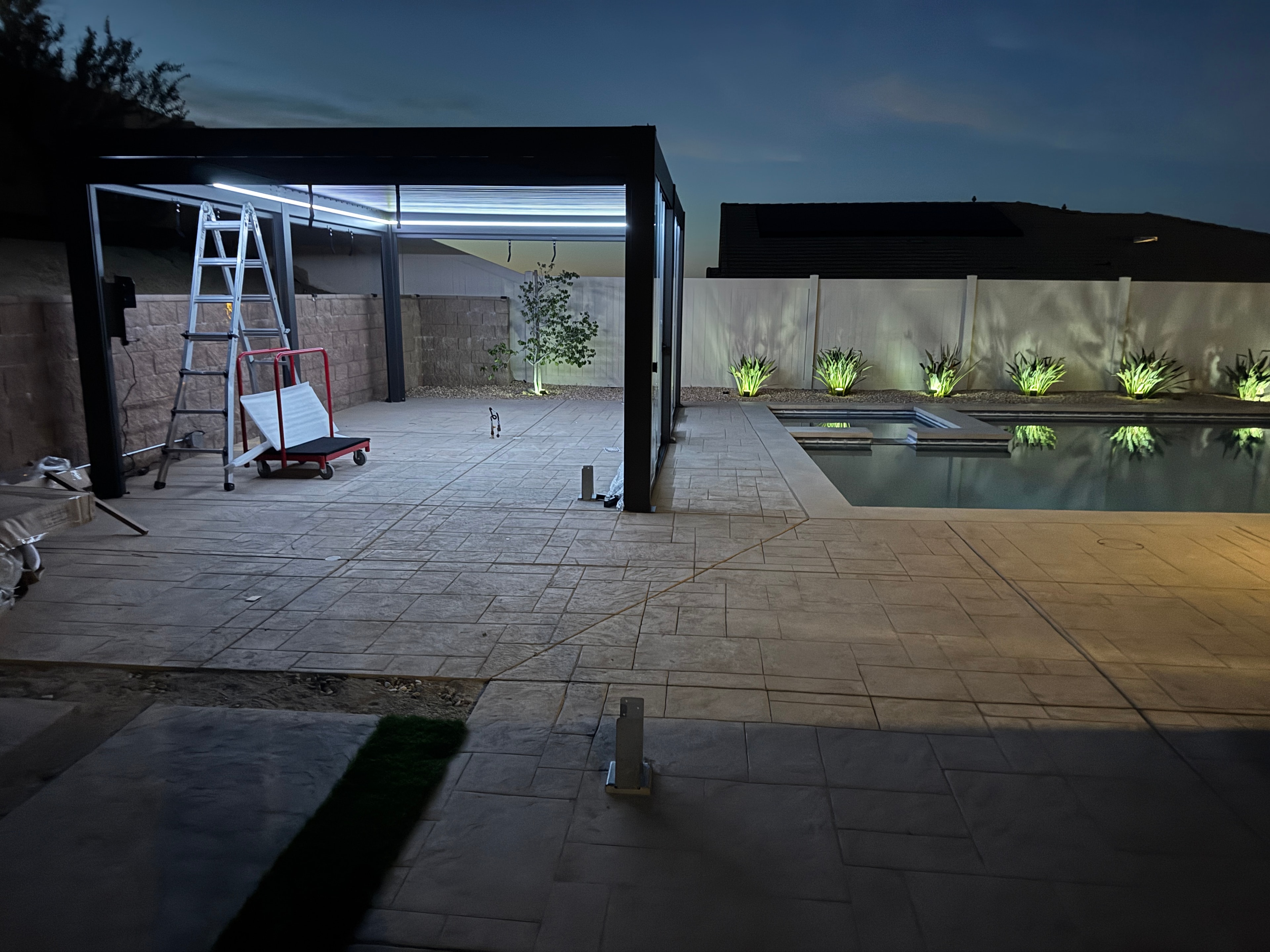 Modular pergola structure installation in progress at night